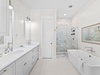 Primary en-suite featuring dual vanities, soaking tub, and walk‑in shower for a luxury retreat.