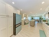 Enjoy preparing meals in this bright, open kitchen featuring modern stainless steel appliances, ample counter space, and a seamless flow into the dining area where ocean breezes drift through.
