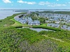 Aerial view of waterfront resort community surrounded by pristine mangroves and tropical waters.