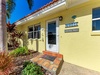A charming tropical entrance welcomes guests with vibrant palm trees and colorful landscaping at this delightful Florida getaway.