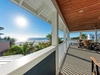 Spacious covered balcony offers stunning ocean views and comfortable seating for your perfect beachside retreat.