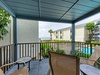 Relax on your private covered balcony with comfortable seating and peaceful pool views.