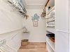 Your well-organized walk-in closet offers abundant storage with shelving, hanging space, and charming coastal touches for a relaxing getaway.