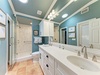 Step into your beautifully appointed bathroom with calming blue tones, dual vanities, and a spacious walk-in shower—a refreshing retreat after a day of exploring.