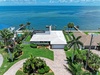 Stunning waterfront property with private dock access, lush tropical landscaping, and expansive bay views. The property features a spacious lawn, boat dock, and prime coastal location.