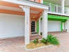 Bright and welcoming facade features vibrant colors, private parking, and easy beach access—your coastal escape awaits.