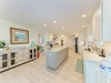Picture yourself preparing meals in this bright, spacious kitchen with gleaming countertops, modern appliances, and a generous center island perfect for gathering and entertaining.