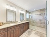 Step into your luxurious spa-like bathroom featuring elegant marble details and a spacious glass shower.