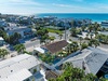Aerial view of coastal residential neighborhood featuring vacation rental properties near pristine beaches and ocean waters.
