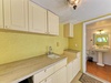 Your private kitchenette features bright sunny walls, ample counter space for meal prep, and direct access to your refreshing en-suite bathroom with a pedestal sink.