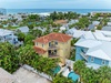 Aerial view of a beachside neighborhood featuring tropical palm trees, residential homes, and easy ocean access.