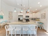 Your coastal-inspired kitchen and dining space awaits, complete with a large island for family meals and pendant lights that glow above. The open layout invites you to cook, gather, and unwind in breezy beachside style.