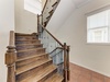 Elegant wooden staircase connects your living spaces, featuring beautifully finished hardwood steps and charming wrought iron railings that blend classic craftsmanship with modern style.