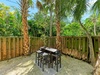 Your private tropical patio offers peaceful outdoor dining beneath swaying palms, creating the perfect spot for morning coffee or evening cocktails.