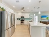 Cook up your favorite meals in this bright, modern kitchen featuring stainless steel appliances, sleek white cabinetry, and a spacious island with seating—perfect for gathering with loved ones.