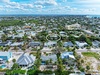 Aerial view of a vibrant coastal neighborhood with palm-lined streets and easy beach access nearby.