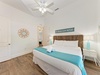 Unwind in your serene coastal bedroom, where soft linens and beachy décor invite restful nights under the gentle glow of ceiling fans.