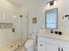 Step into your beautifully appointed bathroom featuring a spacious walk-in shower, elegant vanity, and fresh white linens awaiting your arrival.