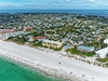 Aerial view of a coastal community showcasing pristine white sand beaches and turquoise waters along the shoreline.