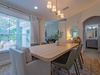 Gather around this elegant dining table for shared meals and memories, bathed in natural light from the large windows overlooking peaceful greenery outside.