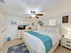 Sink into crisp linens and coastal charm in your peaceful bedroom, complete with ceiling fan and beachy decor.