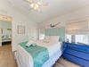 Unwind in your bright coastal bedroom with a plush bed, charming beach-themed decor, and refreshing sea breezes from the windows.