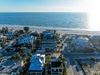Beachfront neighborhood with pristine sandy shores and azure waters stretching to the horizon.