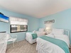 Your peaceful twin bedroom features coastal turquoise tones, crisp white linens, and modern amenities for ultimate comfort.
