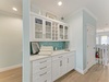 Coastal elegance meets functionality in this butler's pantry featuring soft turquoise accents and ample storage for your entertaining essentials.