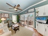Relax in your bright living room with soothing coastal colors, comfy seating, and patio doors opening to an outdoor dining area—a perfect retreat for unwinding after a beach day.