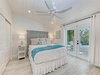 Wake up in your serene coastal bedroom where soft whites and ocean blues create perfect harmony. Step through French doors to your private patio oasis.
