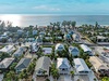 Charming beachfront community with colorful coastal homes nestled between tropical palms and pristine sandy shores.