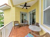 Your private covered balcony invites you to unwind with cozy wicker seating, a dining table, and a ceiling fan to keep you comfortable in the tropical breeze.