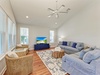 Relax in this bright living room with plush sectional seating, coastal decor, and ceiling fan keeping you comfortable.