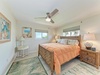 Your bright and breezy coastal bedroom awaits, featuring tropical-inspired furnishings and a ceiling fan for gentle comfort. Wake up to glimpses of ocean views through the window, surrounded by beachy décor that captures the island spirit.