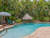 Your private tropical oasis awaits—lounge under the palms by the sparkling pool, unwind on cushioned sunbeds, or cool off beneath the thatched palapa surrounded by lush greenery.