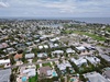 Aerial view of a charming coastal neighborhood with waterfront access, lush greenery, and nearby beaches—perfectly positioned for a relaxing Florida getaway.