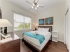 Drift off in your bright, serene bedroom—soft linens, coastal art, and natural light create your perfect retreat. Ceiling fan keeps you cool; hardwood floors add warmth and charm.