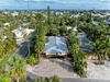Aerial view of a tropical residential neighborhood with palm trees and vacation homes nestled among lush greenery.