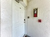 Property entrance with room 202 clearly marked on white door, featuring standard safety equipment in hallway.