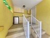 Bright stairwell with cheerful yellow walls leads to your private space, featuring convenient upper-level cabinetry and a mini fridge for easy access to refreshments.