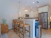 Your bright, coastal-inspired kitchen features a spacious island with woven bar seating—perfect for morning coffee or sharing vacation stories with loved ones.