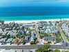 Stunning aerial view of a pristine beachfront community with turquoise waters and white sand beach stretching endlessly.
