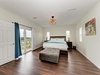 Sink into plush comfort in your spacious primary suite, where natural light pours through multiple windows and your private balcony door opens to coastal breezes and tropical views.