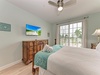 Drift off peacefully in your airy bedroom, where soft linens, a calming ceiling fan, and tropical views from the balcony door promise restful nights and refreshing mornings.