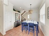 Gather for meals in this bright dining area with vibrant blue seating, warm lighting, and coastal accents that set the stage for shared stories and laughter.