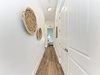 Light-filled hallway connects your private bedrooms, with warm wood floors and coastal-inspired décor creating a peaceful flow throughout your retreat.