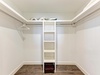 Your spacious walk-in closet offers organized storage with built-in shelving and ample hanging space for all your belongings.