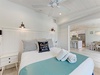 Sink into crisp white linens in your coastal bedroom, where the gentle ceiling fan and charming 