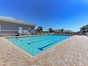 Sparkling community pool surrounded by elegant brick pavers, perfect for morning laps or afternoon relaxation under Florida's endless blue skies.